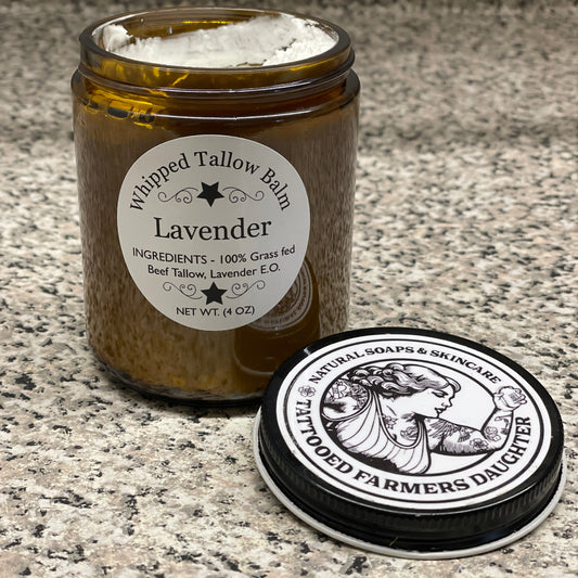 Tall brown bottle of lavender tallow balm with a black and white label on a textured surface