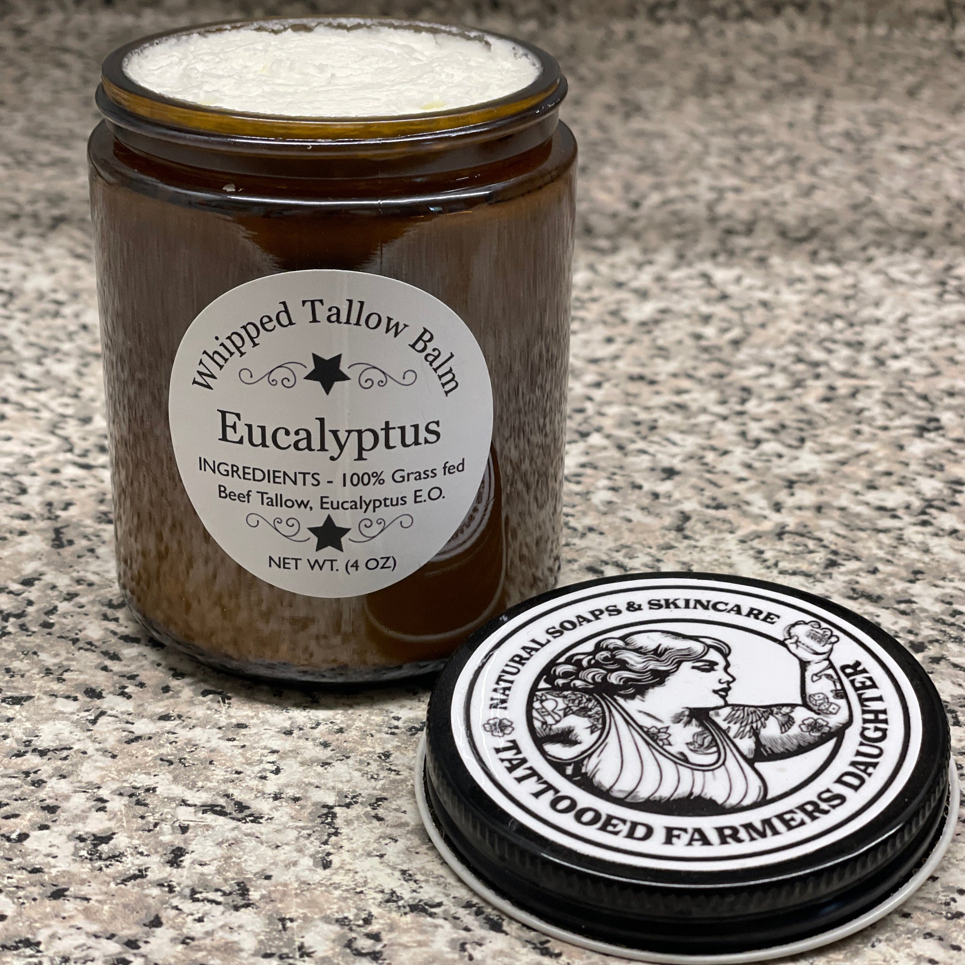 Jar of Wipped Tallow Balm with 'Tattooed Farmer' branding on a textured surface